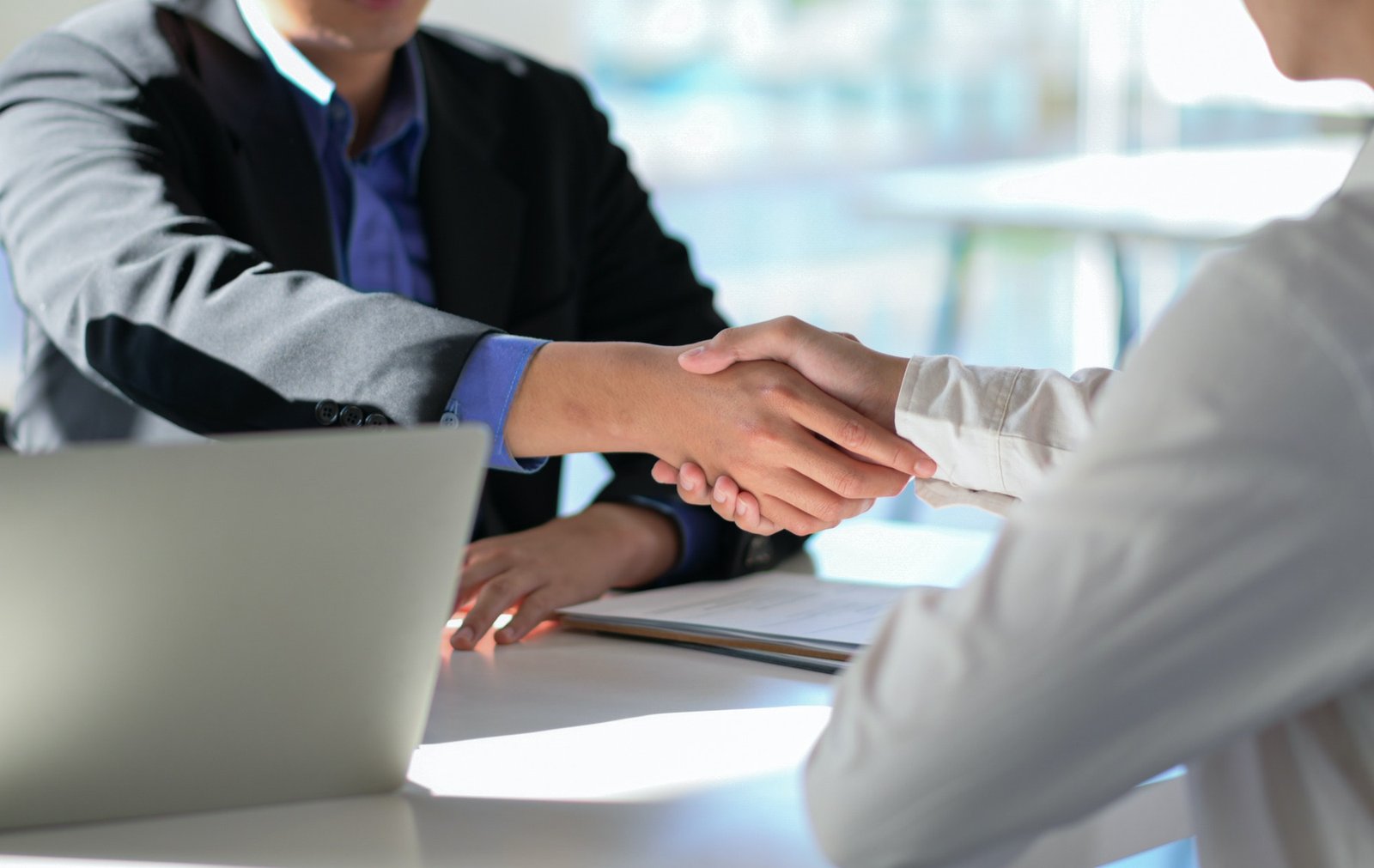 Cropped shot of Executives join hands to congratulate the new employee through the interview.